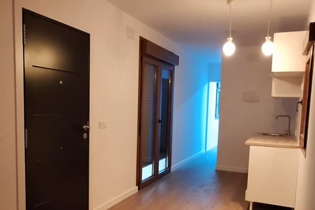 Interior de una vivienda modular: entrada, pasillo y cocina